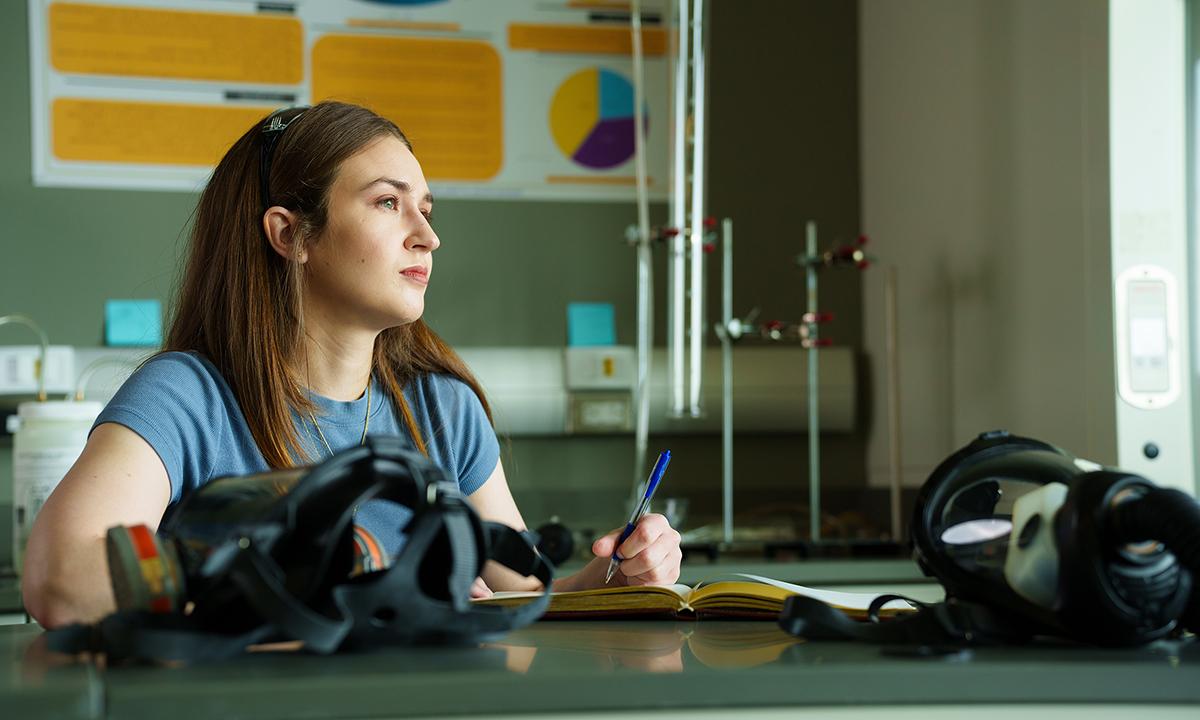 Deanna Fochesato looks up from writing and gazes into the distance